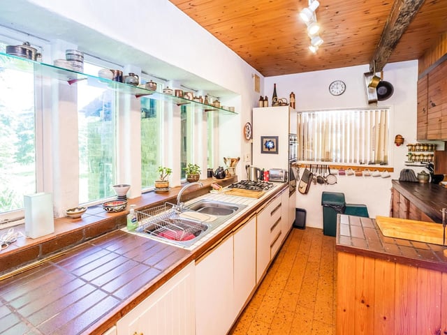 The kitchen has a wall of windows overlooking the gardens.