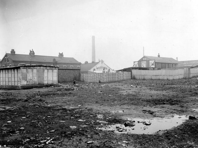 Looking west across the waste ground towards Florence Street in January 1952. The bottom of this view shows the waste ground with two children playing with a tricycle. 