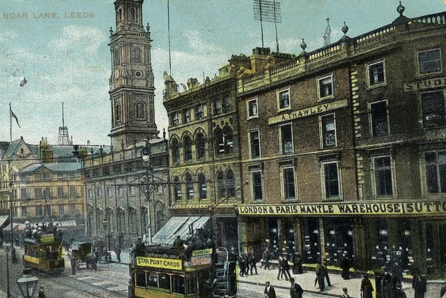A colour tinted postcard with a postmark of August 19, 1907 showing the north side of Boar Lane. On the right is Sutton's London & Paris Mantle Warehouse with the studio of Arthur Thawley, photographer, above. Further along to the left is Holy Trinity Church then Monteith, Hamilton & Monteith Ltd. (The Grand Pygmalion), drapers.