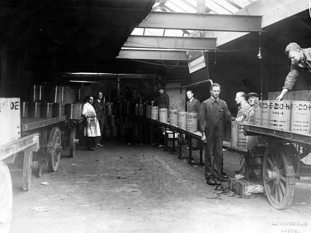 A view looking along a production line at Edward Joy & Sons Ltd, filtrate works on Kidacre Street. Drums of oil, dated March 1945, can be seen with several workers checking them.