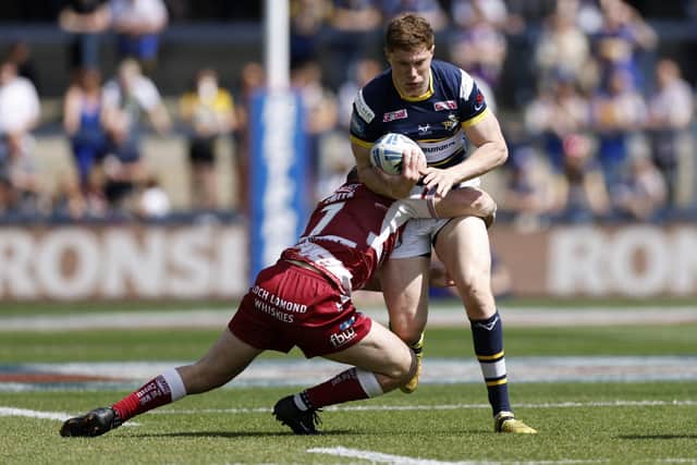 Rhinos' makeshift stand-off Morgan Gannon takes on Wigan's Harry Smith. Picture by Richard Sellers/PA Wire.