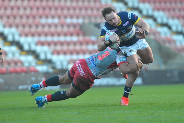 Rhinos' James Donaldson is tackled by John Asiata, of Leigh. Picture by Steve Riding.