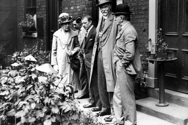 The Lord Mayor, Alderman Hugh Lupton and the Lady Mayoress, Ella Lupton inspect the gardens adjoining brick built terraced housing in Leeds. The display includes window boxes and potted plants as well as bedding plants. Pictured in August 1927.