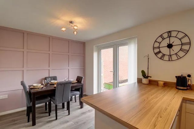 The dining area boasts French doors out to the garden and feature panelling to one wall.
