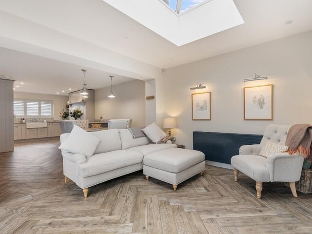 The kitchen flows seamlessly into the dining area and continues into an additional sitting space.