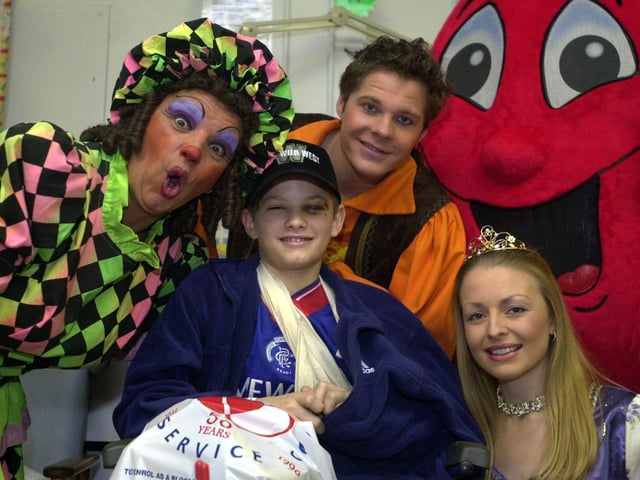 Stars from the cast of Wakefield Theatre's Jack and the Beanstalk joined Billy the Blood Drop, mascot for the National Blood Service, on a visit to children's ward A  at Pinderfields Hospital in December 2000. Pictured is Dame Trott (Phil Haze), Princess Marigold (Sarah Beaumont) and Jack (Roman Marek) with young patient Adam Heartley.