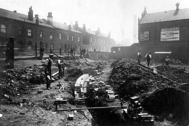 Workmen at a trench on Torre Road. Houses can be seen on the left and the Regent Cinema on the right. Pictured in July 1931.