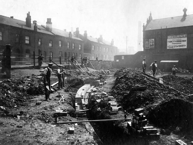 Workmen at a trench on Torre Road. Houses can be seen on the left and the Regent Cinema on the right. Pictured in July 1931.