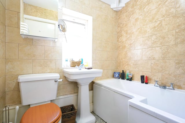 The house bathroom has a wonderful spacious bath tub and marbled walls.