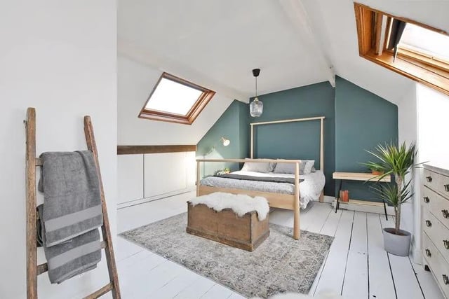 The spacious attic bedroom is bright and airy having front and rear facing Velux windows, lovely decor, white exposed floorboards, eaves storage and woodland views to the front.