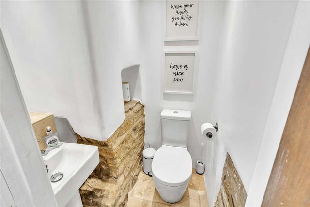 The downstairs toilet similarly features exposed stonework along with a modern contemporary wc unit and basin.