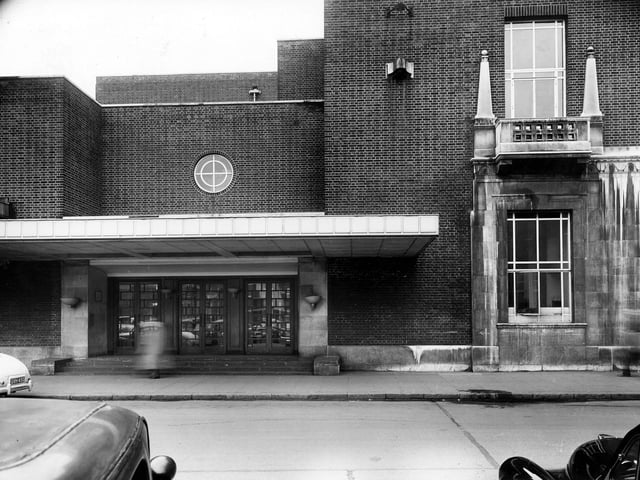 A view of the side entrance to the Queens Hotel on New Station Street in August 1957. Designed by architect William H. Hamlyn, the hotel opened on November 12, 1937 as part of the newly built Leeds City Station complex. It replaced an earlier Queen's Hotel that had previously occupied the site.