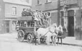 A horse-drawn omnibus stands outside the Bay Horse Hotel on Benson Place in June 1901. The omnibus, proprietor, John Thomas Bean & Son, is loaded with passengers on both the upper and lower deck. It is drawn by three horses. Mr. Bean, seated in the centre with whip, is dressed identically to the young man standing, most likely his son. They are wearing suits, cloth caps and are sporting button holes. The Bay Horse Hotel, at this time was run by Walter Newbould. The shop in the background, left is at the corner with Woodhouse Hill Terrace and is numbered 14 Woodhouse Hill Road, The Central Drug Store. The lettering on the side of the omnibus says 'Briggate' and 'Hunslet Carr'.