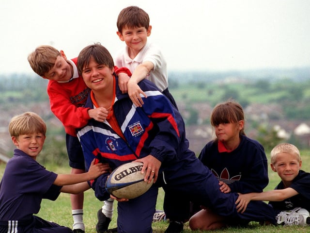 Wakefield Panthers Rugby League player Kirsty Robinson is tackled by some of the Kippax Gibson Lane Junior School pupils . Pictured, from left, are Liam Costello, Daniel Hall, Mark Curtiss, Alex Beardmore and Sam Field.