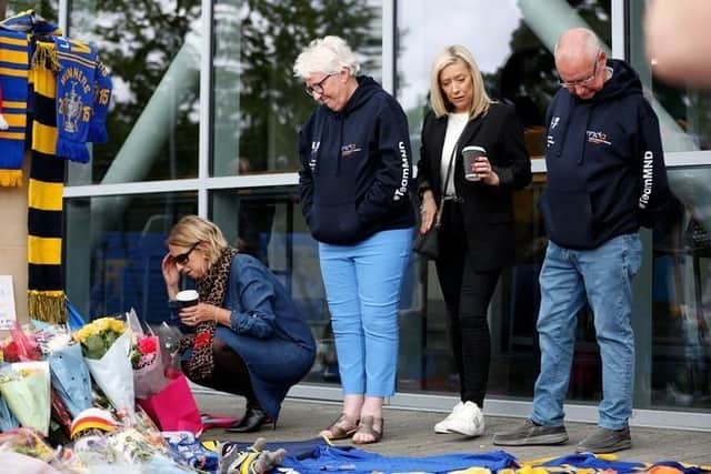Rob Burrow's parents Irene and Geoff Burrow and his sisters Claire Burnett and Joanne Harsthorn look at tributes left at AMT Headingley. Picture by Ed Sykes/Getty Images.