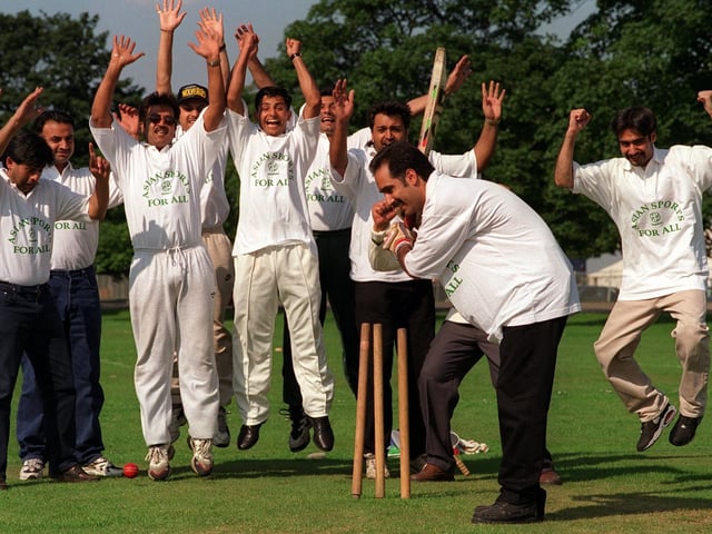 Howzat! Councillor Javed Akhtar, organiser of the "Asian Sport for All" cricket tournament on Soldiers Field in August 1997 is clean bowled, as competitors in the competition celebrate.