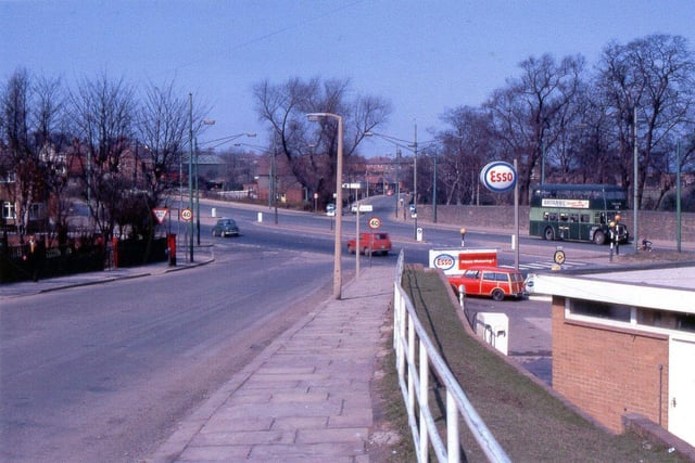 A view looking along Armley Ridge Road in April 1969 to where it crosses Stanningley Road. Armley Grange Avenue is to the left, an ESSO petrol station is to the right. A green no.14 bus is on Stanningley Road.