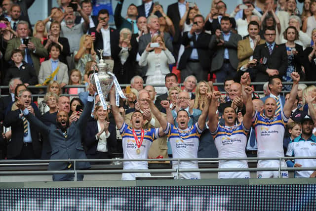 Kevin Sinfield lifts the Challenge Cup, along with injured teammate Jamie Jones-Buchanan, after Rhinos' victory at Wembley in 2015. Picture by Steve Riding.