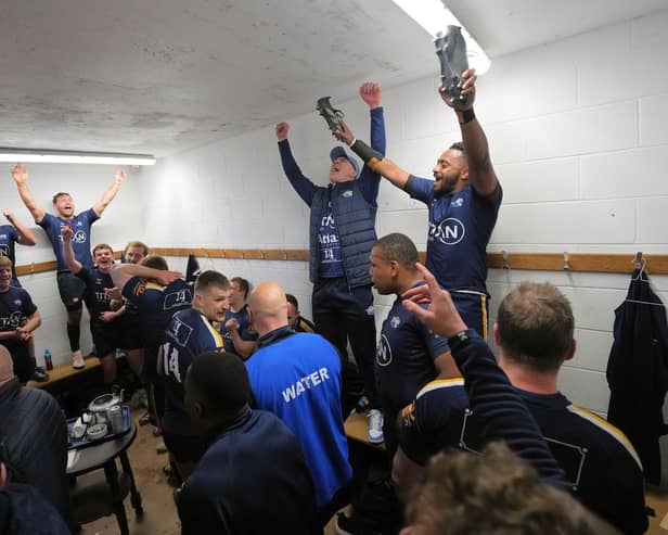 On the up: Leeds Tykes players and staff celebrate in the changing rooms after their promotion to National One was confirmed. Picture courtesy of Mike Inkley.