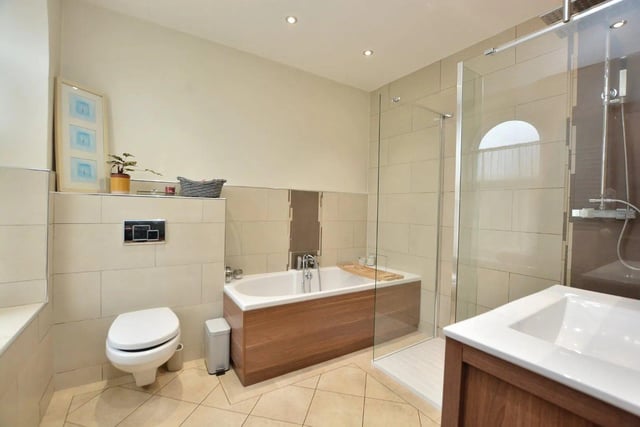 The family bathroom is part-tiled and fitted with a modern white suite including a large walk-in shower enclosure, separate bath, washbasin and WC.