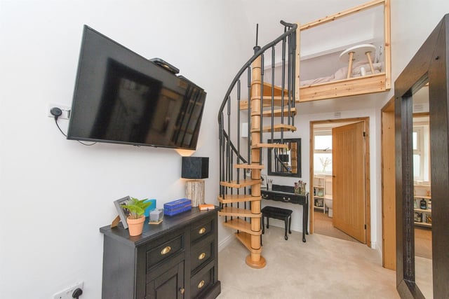 Spiral staircases, one leading to a mezzanine level, add interest to the interior.