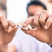 Two hands breaking a cigarette