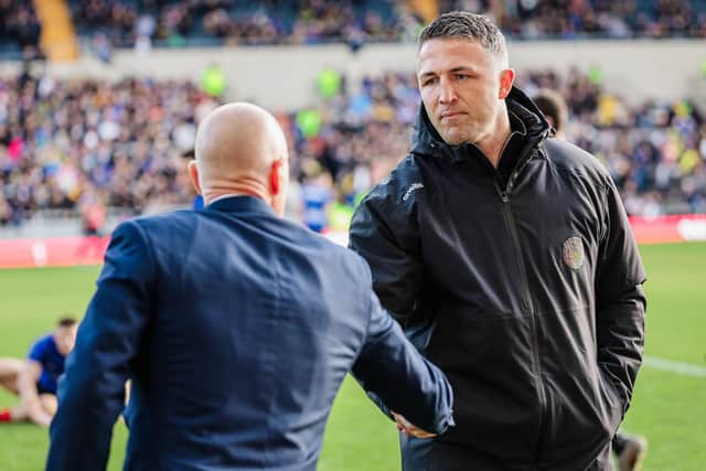 Warrington Wolves coach Sam Burgess, right, shakes hands with Leeds Rhinos rival Brad Arthur ahead of the sides' meeting at AMT Headingley in March. Picture by Alex Whitehead/SWpix.com.