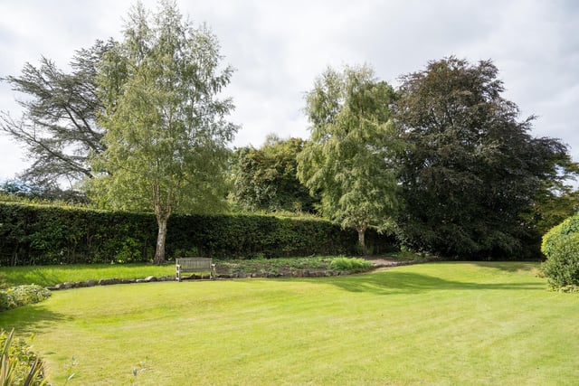 Grounds of around half an acre have a mature front garden, and private rear lawned and tiered gardens with trees and hedges.