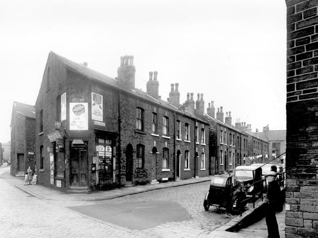 Buslingthorpe Lane is on the left, looking towards the junction with Sheepscar Street/Scott Hall Road. A group of women and children can be seen at the corner of Laycock Street. At the corner with Husler Street is a grocers shop, business of Israel Landy. Pictured in July 1958.