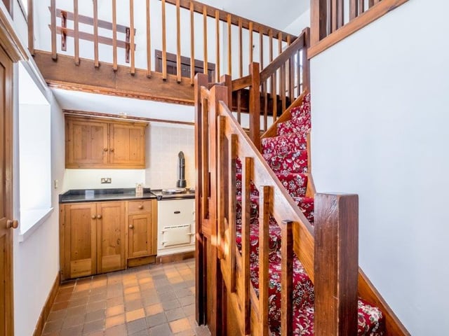 A glimpse of the kitchen and the staircase leading up to two further floors with mezzanine levels.