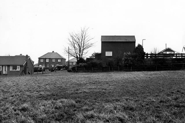 Looking across fields of Haigh Moor Farm to semi-detached housing in Haigh Moor Road in  May 1979. Homes in Holly Court can be seen right of centre.