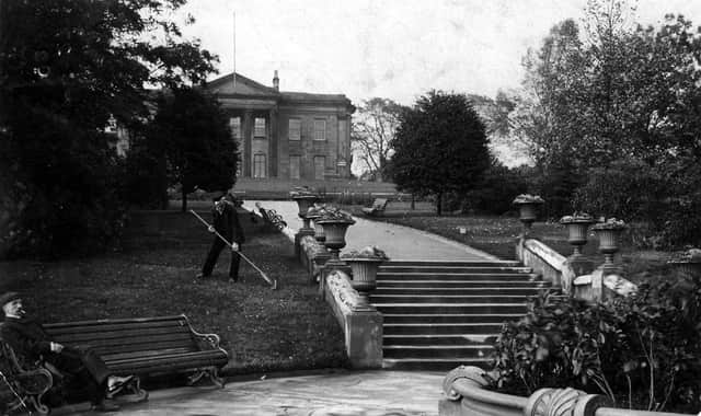 A man is tending to the grass while another man relaxes on a bench in this postcard view of The Mansion. It is postmarked October 27, 1908.