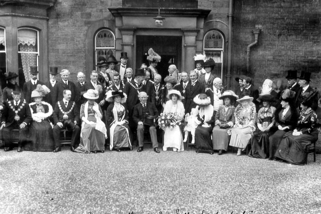 A photo taken at Morley Grange, Elland Road in Jukly 1913 where a garden party is taking place in honour of the Prime Minister, Herbert Henry Asquith, centre. His daughter, Violet, is seated beside him holding a bouquet of flowers. The Mayor of Morley, William Law Ingle is standing behind Mr. Asquith and the Mayoress, his wife, Janet Ingle is seated beside the Prime Minister. Their small grand-daughter, Nancy, is placed next to Miss Asquith. Standing in front of the left-hand door pillar, and wearing a top hat, is Alderman Sam Rhodes, who was four times Mayor of Morley. The long-serving Morley Town Clerk, Fred Thackray, is on the second row, fourth from the right. It is said that, due to fear of demonstration by suffragettes who strongly disliked Mr. Asquith's policies, over 200 policemen were deployed around the house during his stay there
