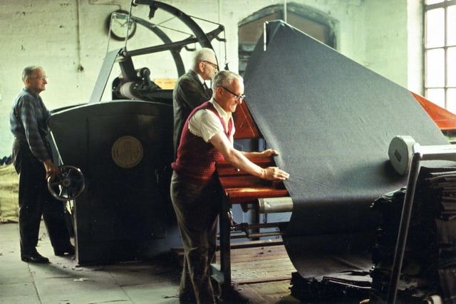 This machine in the finishing department was used to straighten and fold the lengths of cloth that had just been perched at their full width. Here, three workers are operating the machine, including R. Crowther at the front and G. Newstead behind him.