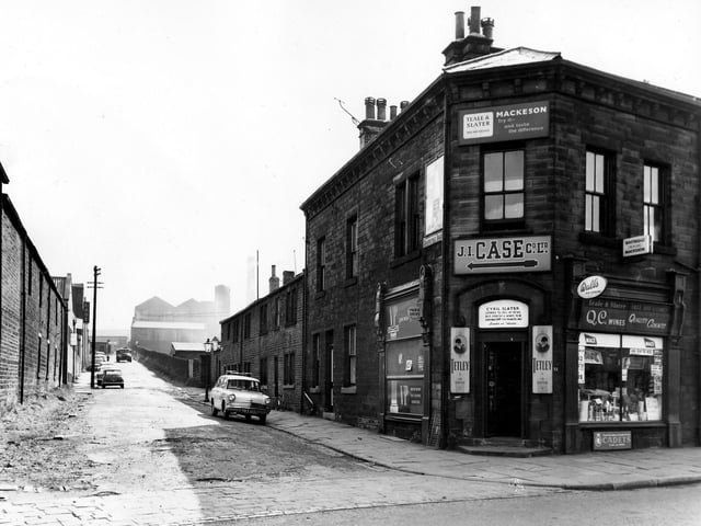 On the left of the image is a view up Grangefield Road towards the bridge and structural engineers at Albion Works. On the right is number 31 Town Street the Teale and Slater off licence run by Mr Cyril Slater. Products on sale include VP wines, Mackeson ales, Tetley's, QC wines, Wall's ice cream and cigarettes. A sign above the shop gives directions to the J.I. Case Co. Ltd. Pictured in September 1963.