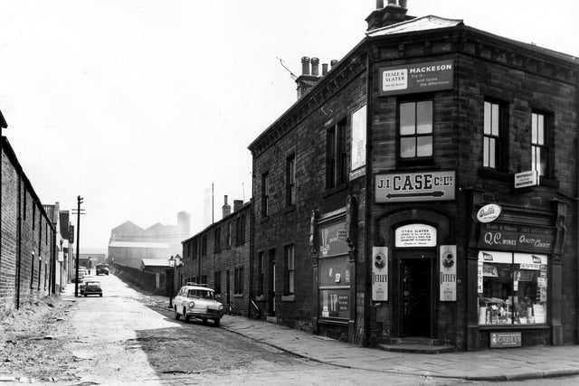 On the left of the image is a view up Grangefield Road towards the bridge and structural engineers at Albion Works. On the right is number 31 Town Street the Teale and Slater off licence run by Mr Cyril Slater. Products on sale include VP wines, Mackeson ales, Tetley's, QC wines, Wall's ice cream and cigarettes. A sign above the shop gives directions to the J.I. Case Co. Ltd. Pictured in September 1963.