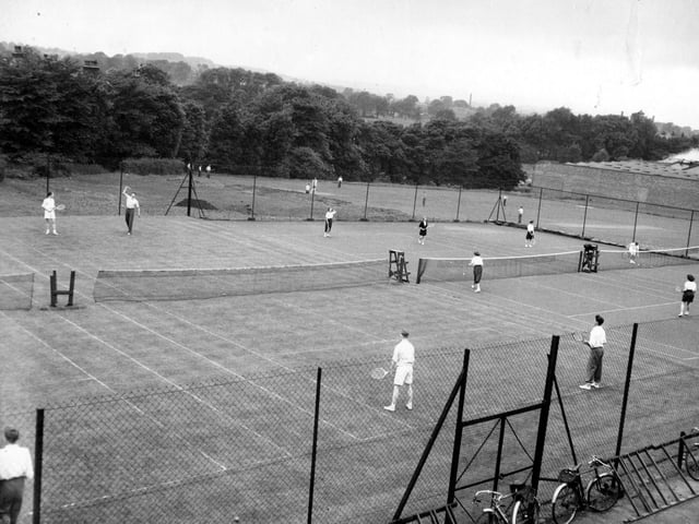 The playing field and tennis courts at Aireborough Grammar School in 1955. The school was opened in 1910 as Yeadon and Guiseley Secondary School. The name was later changed to Aireborough Grammar School. By the 1980s, it was said that pupil numbers were falling and the building was closed in 1991. After demolition a housing estate was built on the land. To the right on this view can be seen the wall which marked the boundary of Peates mill, and some of the factory units.