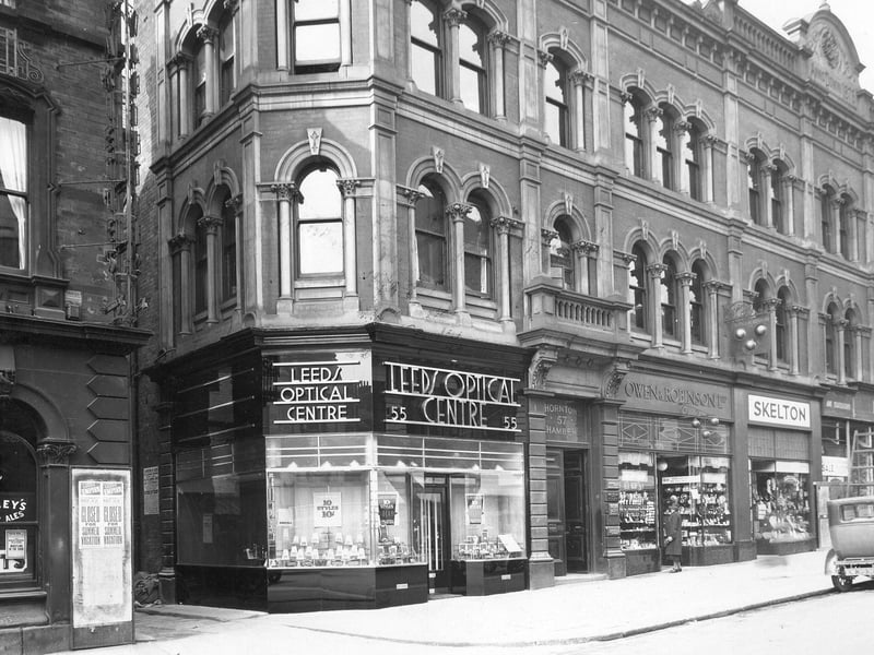 The new Leeds Optical Centre at 55 The Headrow which is in Thorntons buildings on the corner opposite the Horse & Trumpet public house and separated by an alleyway to the City Palace of Varieties. Going to the right we see Owen & Robinson pawnbrokers, Skeltons hosier. The Reeds Empire poster on the pub wall says closed for the summer vacation. Pictured in July 1935.
