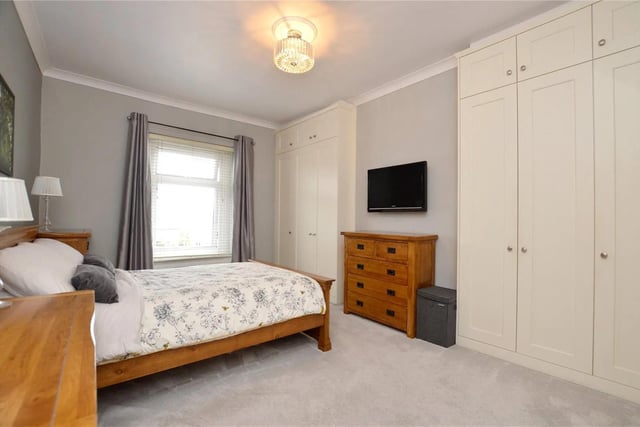 To the first floor, the master bedroom is fitted with a range of custom made shaker-style wardrobes, incorporating ample shelving and hanging space.