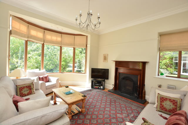 On the ground floor is a lovely large entrance hall with decorative windows, leading into the living room with a deep bay window and a feature fireplace.