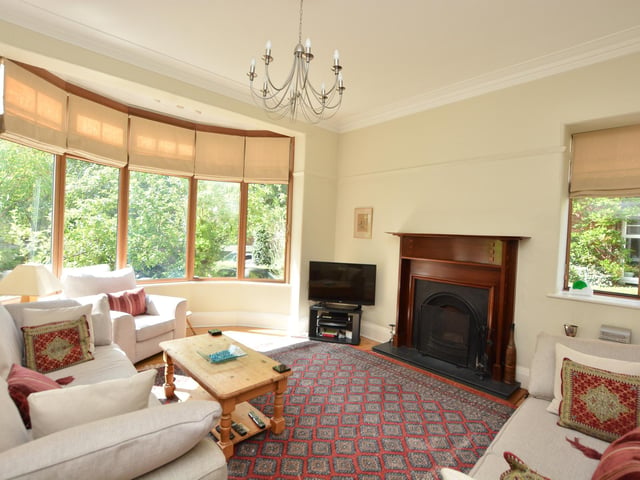 On the ground floor is a lovely large entrance hall with decorative windows, leading into the living room with a deep bay window and a feature fireplace.