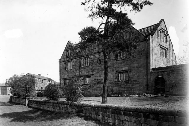 Alwoodley Old Hall pictured in April 1950 which was to the side of Eccup reservoir off a footpath, now Sand Moor golf course. The photo is an exterior view from the south east of the stone multi-gabled, mullioned windowed hall with lawned gardens.