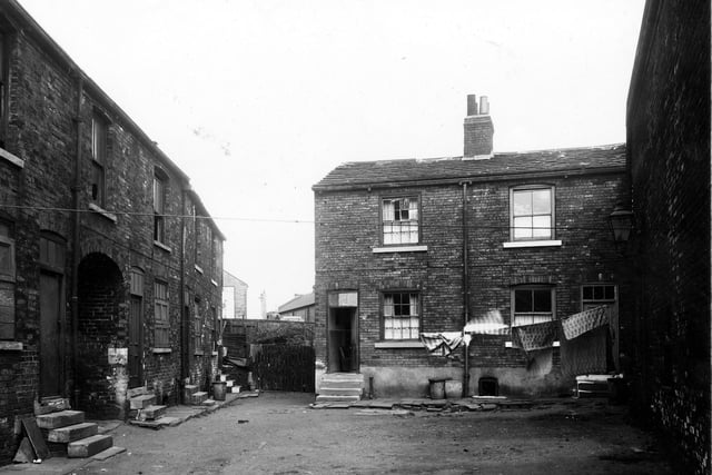 Red Lion Yard, a row of back-to-back terraced properties with an archway on the left allowing access to and from Thwaite Gate. Pictured in July 1959.