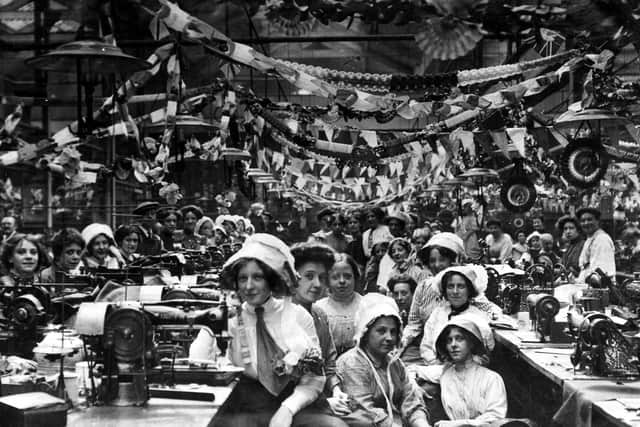 Staff seated at their Singer sewing machines at the firm of John Barran and Sons Limited, wholesale clothing manufacturers in Chorley Lane. The workplace is festooned with decorative bunting and paper chains, from which are suspended rosettes displaying the portrait of George V. The elaborate decorations are in celebration of his coronation which took place on June 22, 1911. Many of the women are wearing bonnets, some trimmed with flowers. PIC: Leeds Libraries, www.leodis.net
