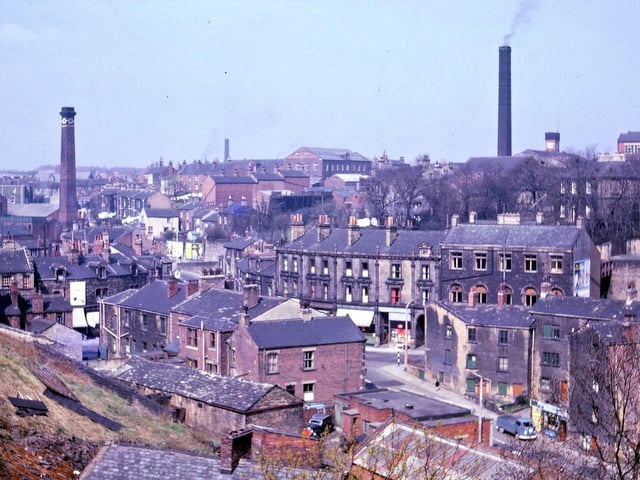 Looking across Morley Bottoms from the escarpment along the edge of Troy Road. The escarpment looks to have been cut into and stone quarried from it. Some of the buildings in Morley Bottoms have then been built close to the escarpment. The buildings in the Bottoms date from about 1895-1900 or considerably earlier, especially the group between Chapel Hill and Station Road. Most of the mills shown are part of one mill - J. S. Rhodes' Prospect Mills whose front is on Victoria Road, not seen here, and whose back is off Bank Street at a level above the the roofs of Cheapside. The tall building on the right, the water tower, the mill chimney on the right and the brick building in the centre (formerly Providence Mill) all belong to Prospect Mills. The chimney on the left belongs to Victoria Mill (Benn and Webster's).