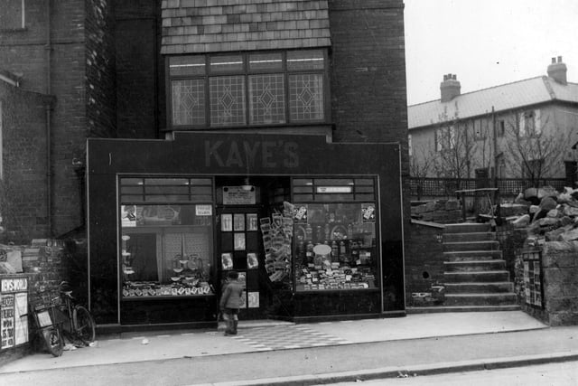 A bicycle is parked outside and a little boy can be seen looking in the shop window of William Kaye's newsagents on Broad Lane in April 1936.