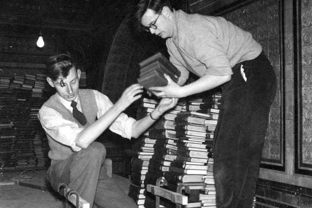 The Library of Commerce, Science and Technical moved from cramped conditions in the Art Gallery to more spacious premises in the Tiled Hall of the Central Library, in which a new gallery had been put up providing further storage and work space. 20,000 books were transported from the basement to this gallery. Pictured are two library workers stacking up the books on their arrival. Behind, part of the elaborate tiling on the walls is visible; this was hidden from view for so long until the gallery was pulled down during the Library's closure in 1999-2000. Finally restored, the Tiled Hall re-opened to the public in June 2007.