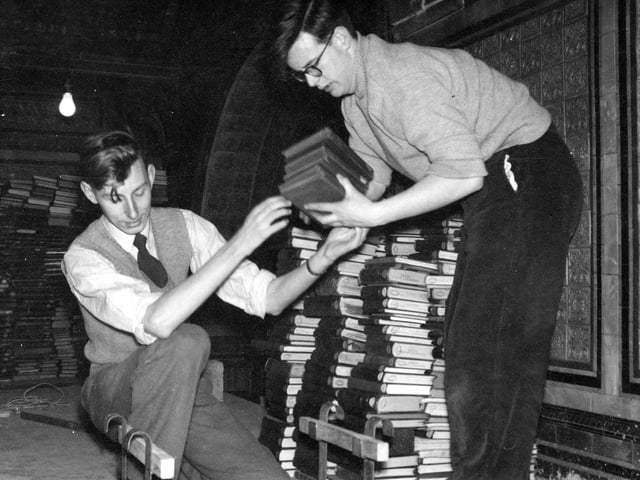 The Library of Commerce, Science and Technical moved from cramped conditions in the Art Gallery to more spacious premises in the Tiled Hall of the Central Library, in which a new gallery had been put up providing further storage and work space. 20,000 books were transported from the basement to this gallery. Pictured are two library workers stacking up the books on their arrival. Behind, part of the elaborate tiling on the walls is visible; this was hidden from view for so long until the gallery was pulled down during the Library's closure in 1999-2000. Finally restored, the Tiled Hall re-opened to the public in June 2007.