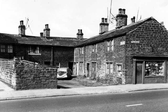 A square of six blind back and through by light terraced houses in Elmwood Square off Town Street. On the left is row of shared outside toilets. On the right is number 62a Town Street a shop called Coles selling transistors with a six month guarantee.