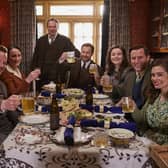 A snap from the All Creatures Great and Small Christmas Special. Pictured: Cast left to right - Callum Woodhouse as Tristan Farnon, Anna Madeley as Mrs Hall, Tony Pitts as Richard Alderson, Samuel West as Siegfried Farnon, Imogen Clawson as Jenny Alderson, Nicholas Ralph as James Herriot and Rachel Shenton as Helen Herriot. Photo: Helen Williams/Channel 5/Playground